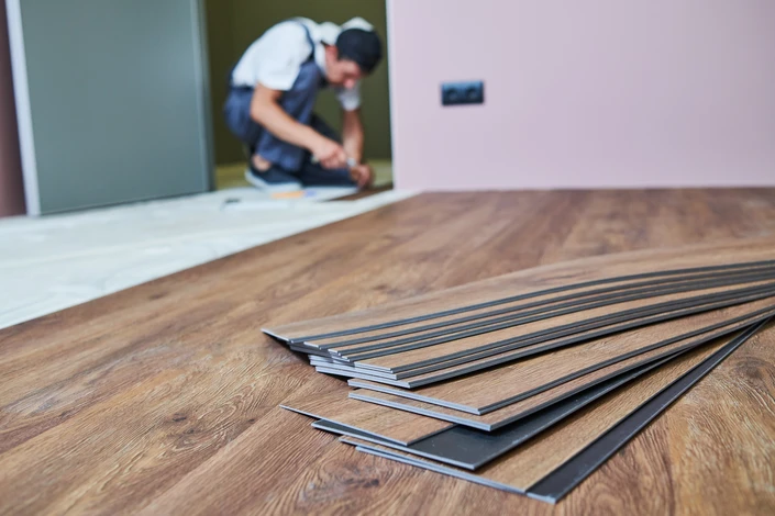 Intérieur résidentiel avec artisan installant du parquet au sol