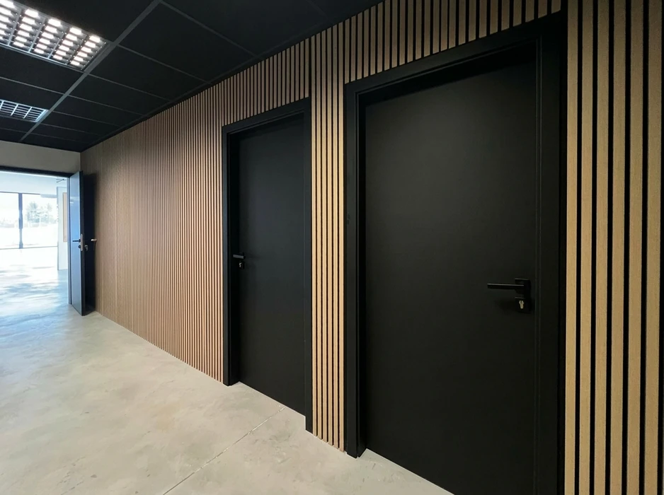 Couloir intérieur moderne avec cloison décorative en lambris à tasseaux verticaux bois clair sur fond noir