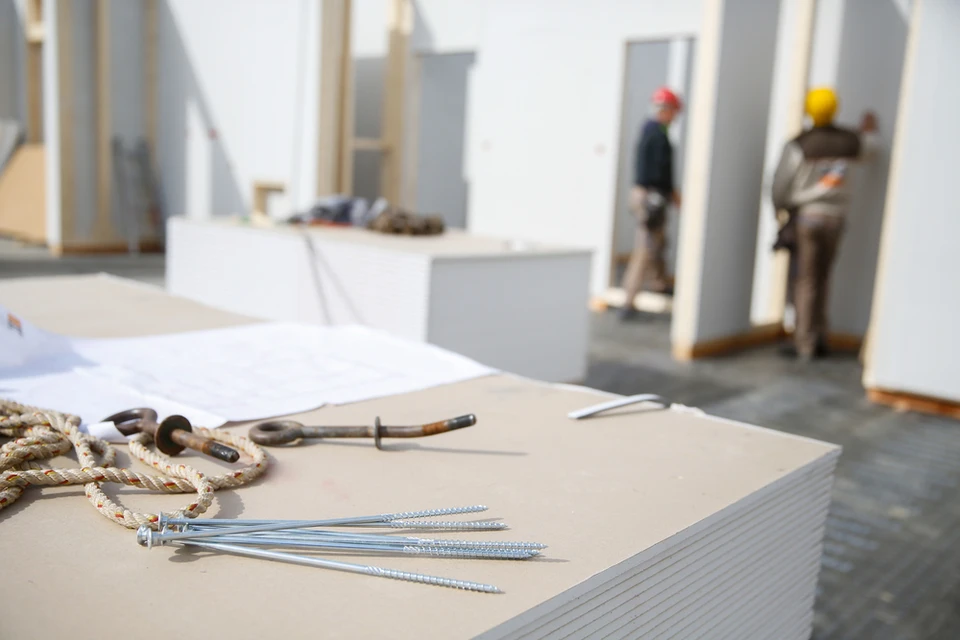 Chantier de construction intérieur avec ouvriers en casques de sécurité travaillant dans un espace en rénovation