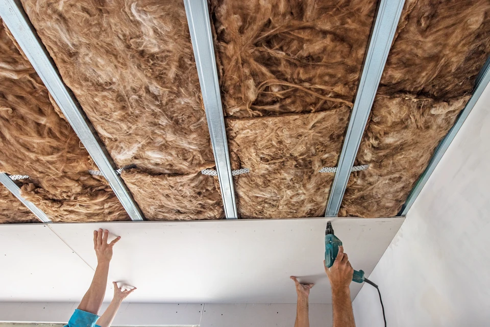 Chantier de r&eacute;novation int&eacute;rieur avec ouvrier installant un plafond suspendu
